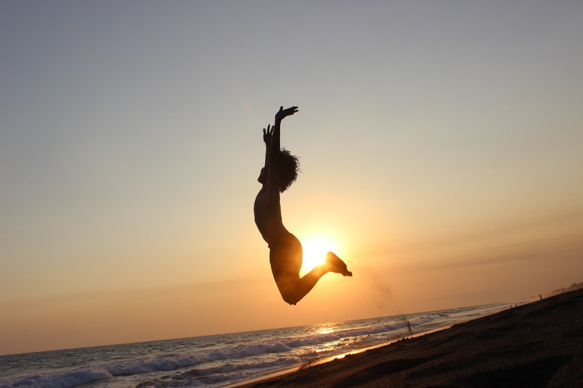 Person jumping in the air at the beach.