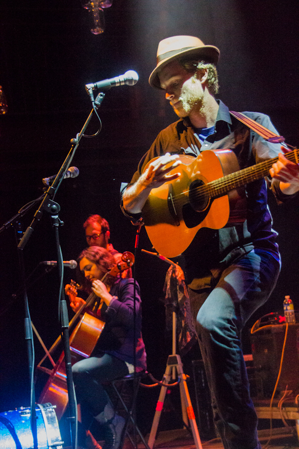 Wesley from The Lumineers plays guitar at a live show.